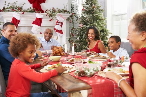 Family With Grandparents Enjoying Christmas Meal At Table